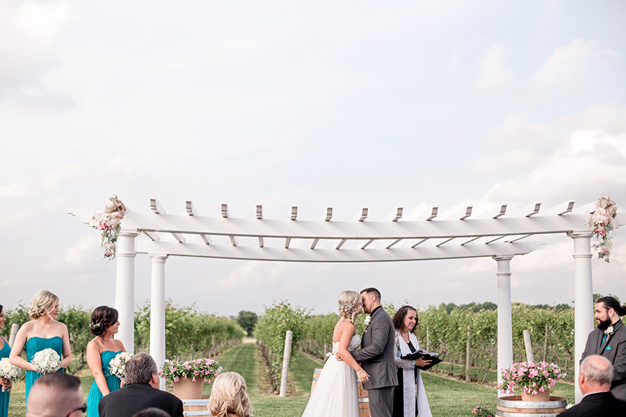 first kiss underneath pergola at tomasello winery
