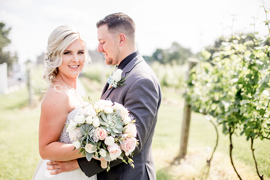 bride and groom give each other a hug at tomasello winery