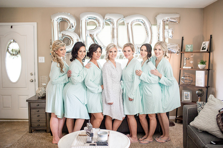 bridesmaids pose with the bride balloons