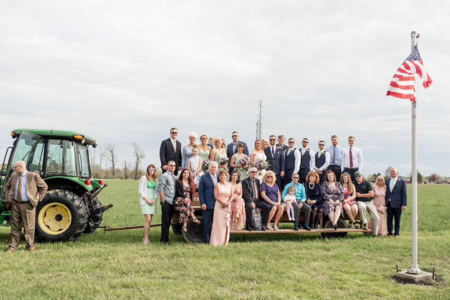 guests pose on tractor at rustic Warner Road Farm wedding 