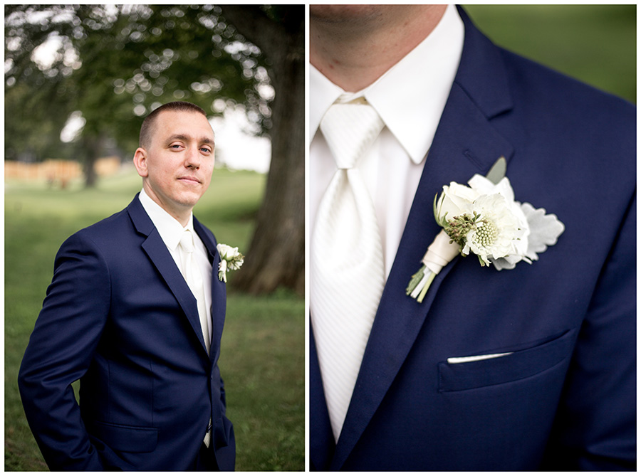 groom in a navy suit with a white flower