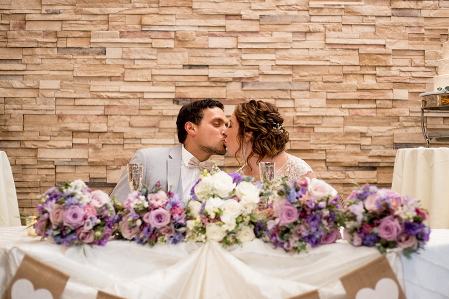 bride and groom kiss at their sweetheart table