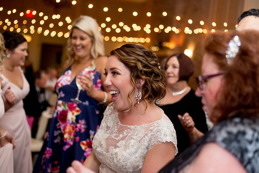 bride dances with her friends under the cafe lights at the reception