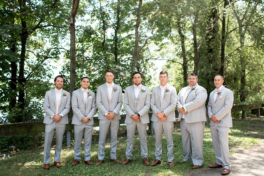 groom with his groomsmen all wearing gray tuxes