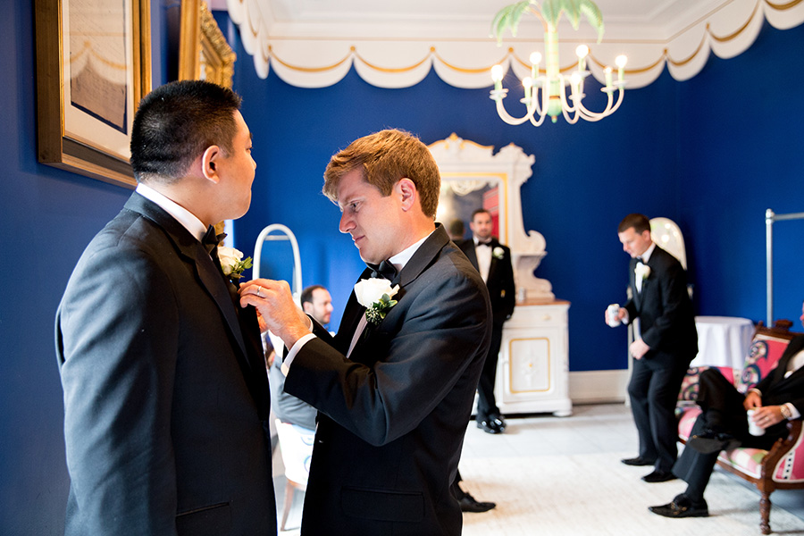 groomsmen straighten their ties before wedding at congress hall