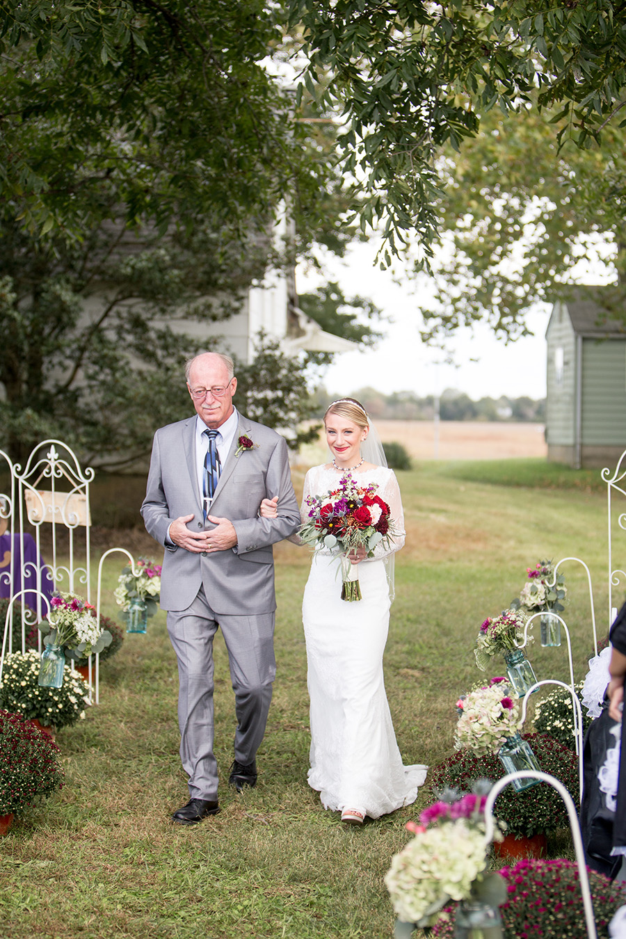 bride escorted down the aisle by her father at her farm ceremony
