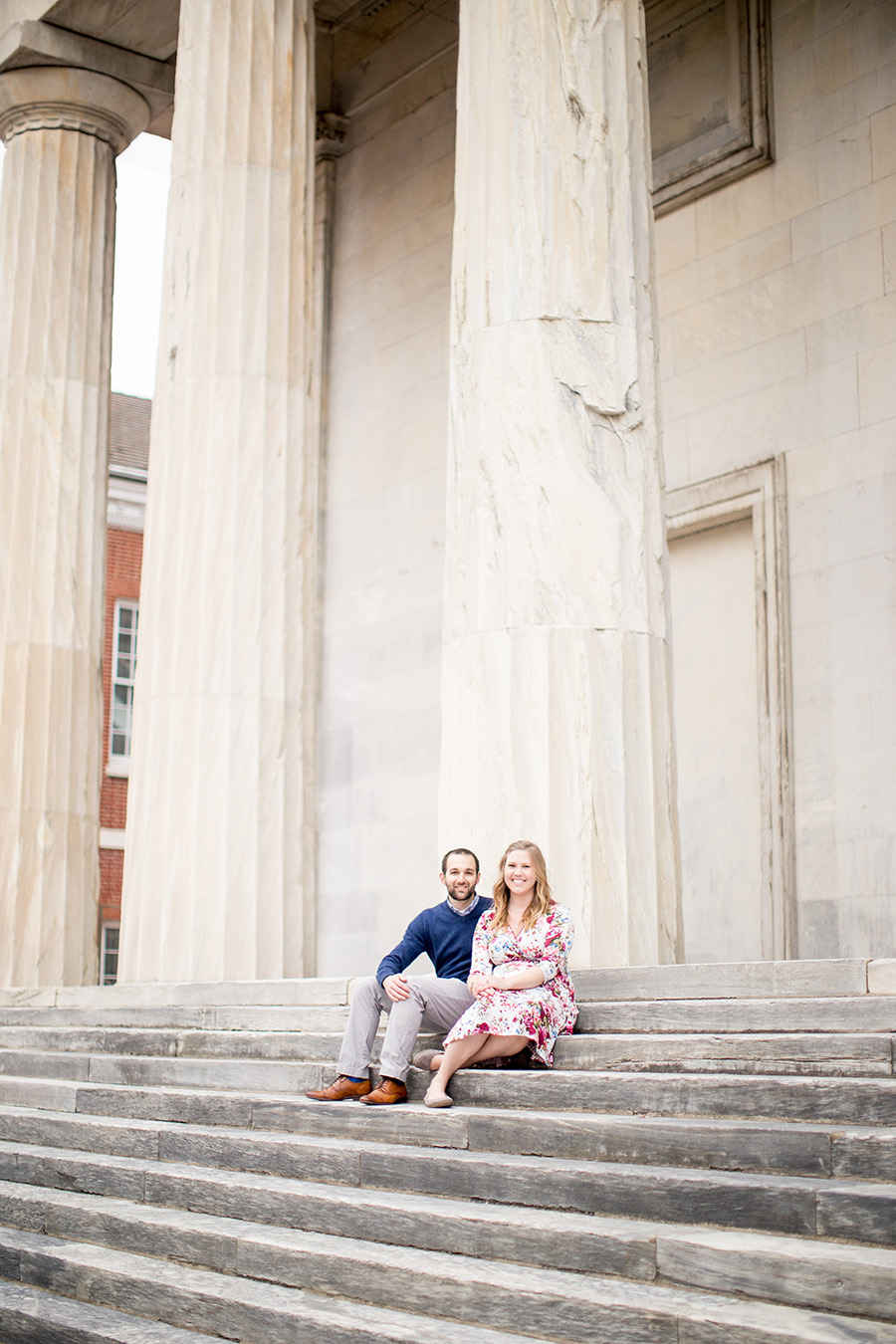 engaged pair sits on steps together