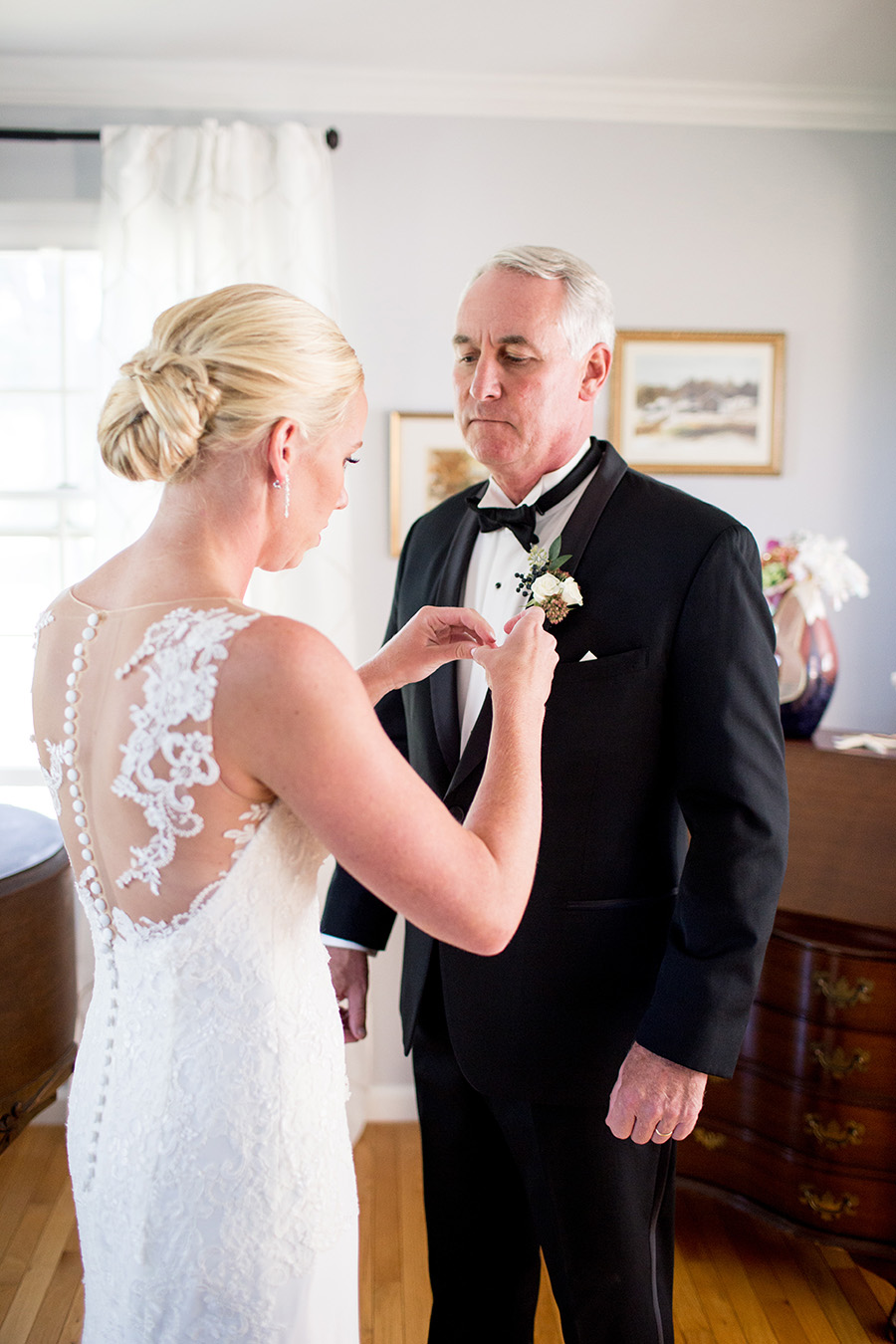 bride pinning boutonniere on her dad 