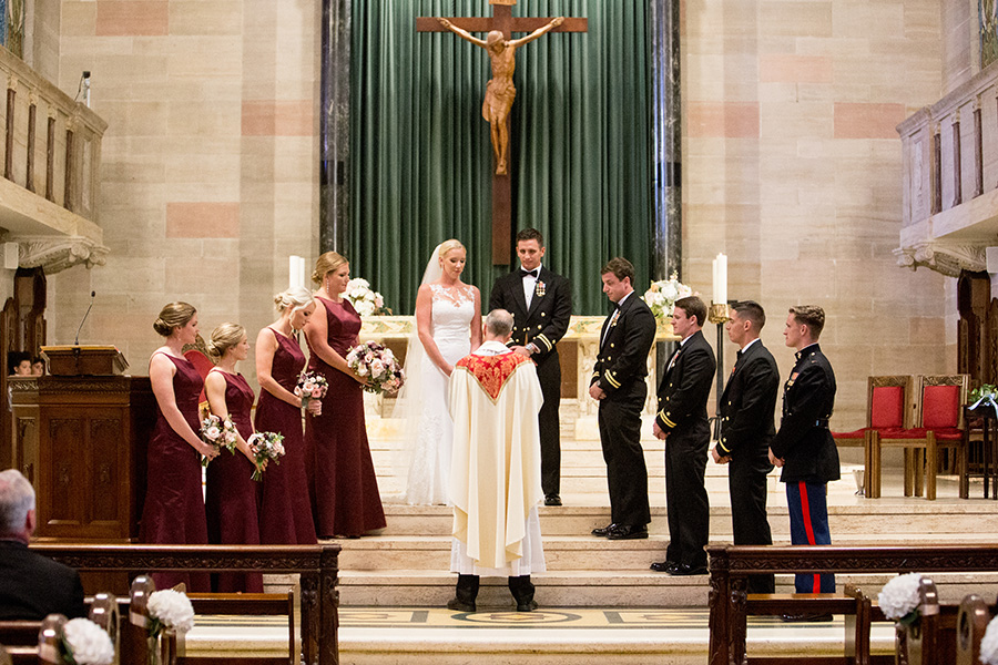bridesmaids and groomsmen stand with the couple at the altar