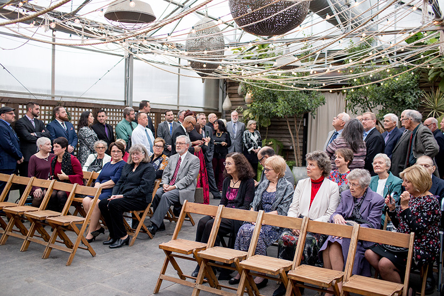 guests seated at indoor greenhouse ceremony space at terrain