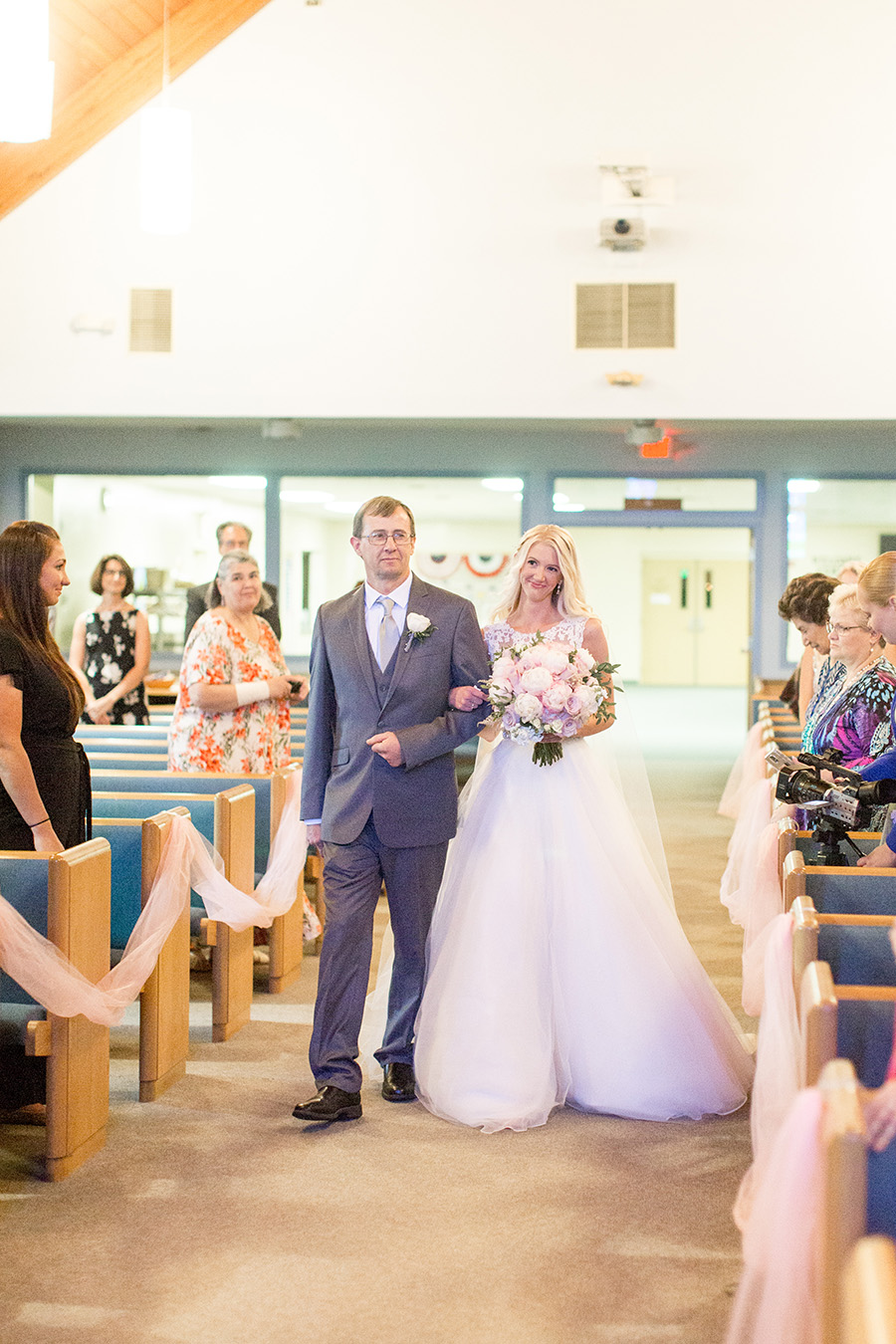 bride walks down church aisle