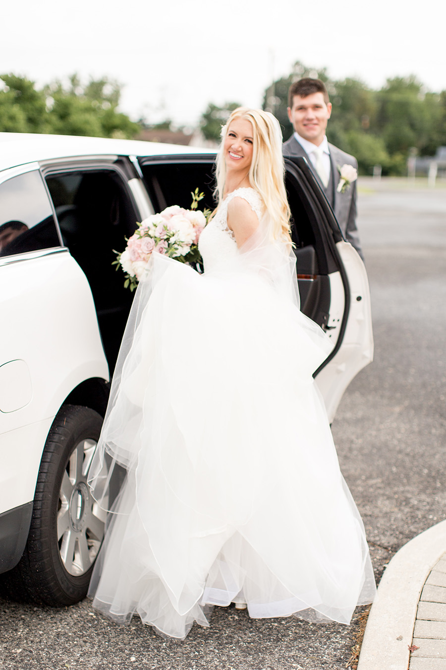 bride and groom head to blue heron in a limo