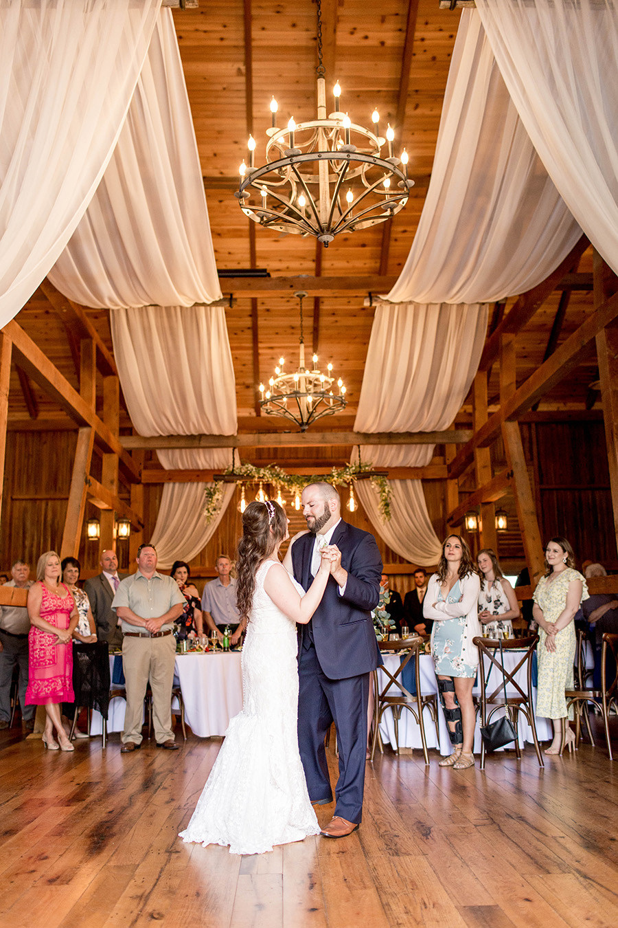 couple shares their first dance in the barn