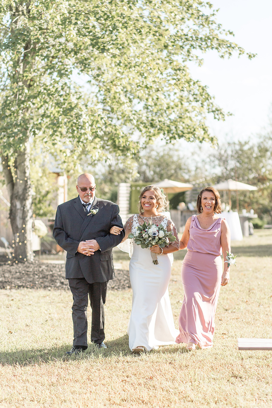 Brides walks down the aisle with her parents