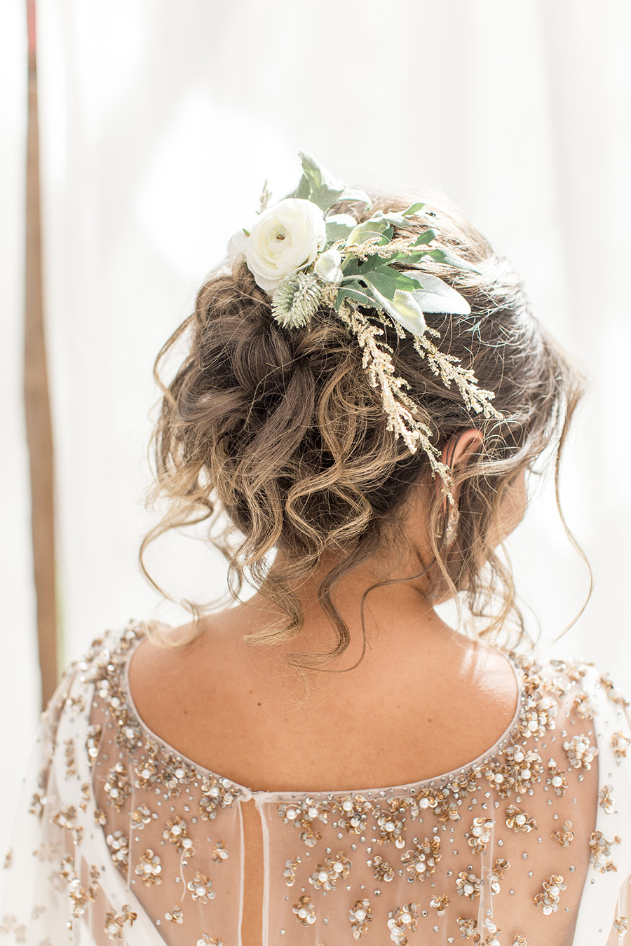 Messy wedding updo with floral hairpiece