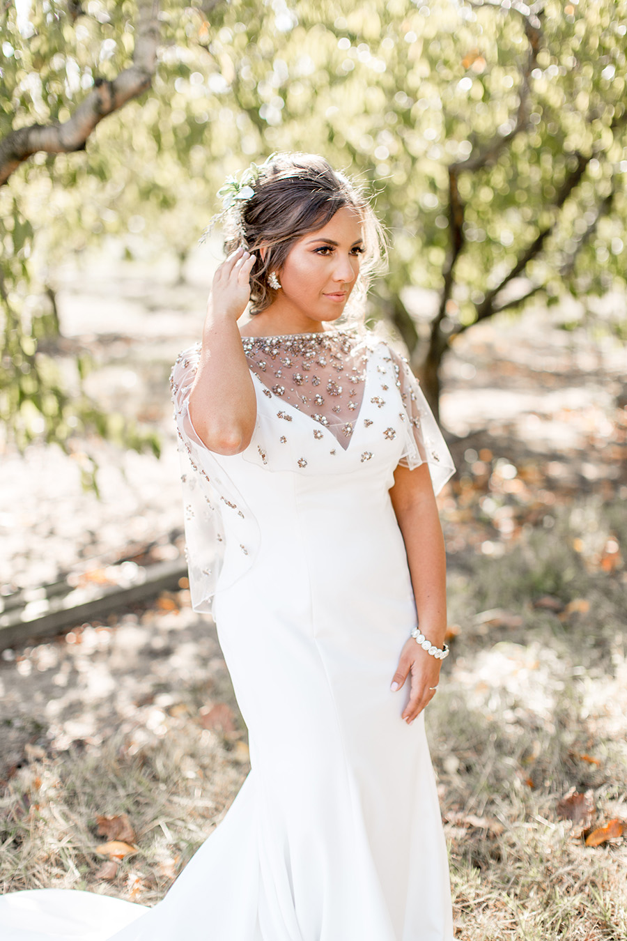 Bride in plunge neck white dress and wedding capelet