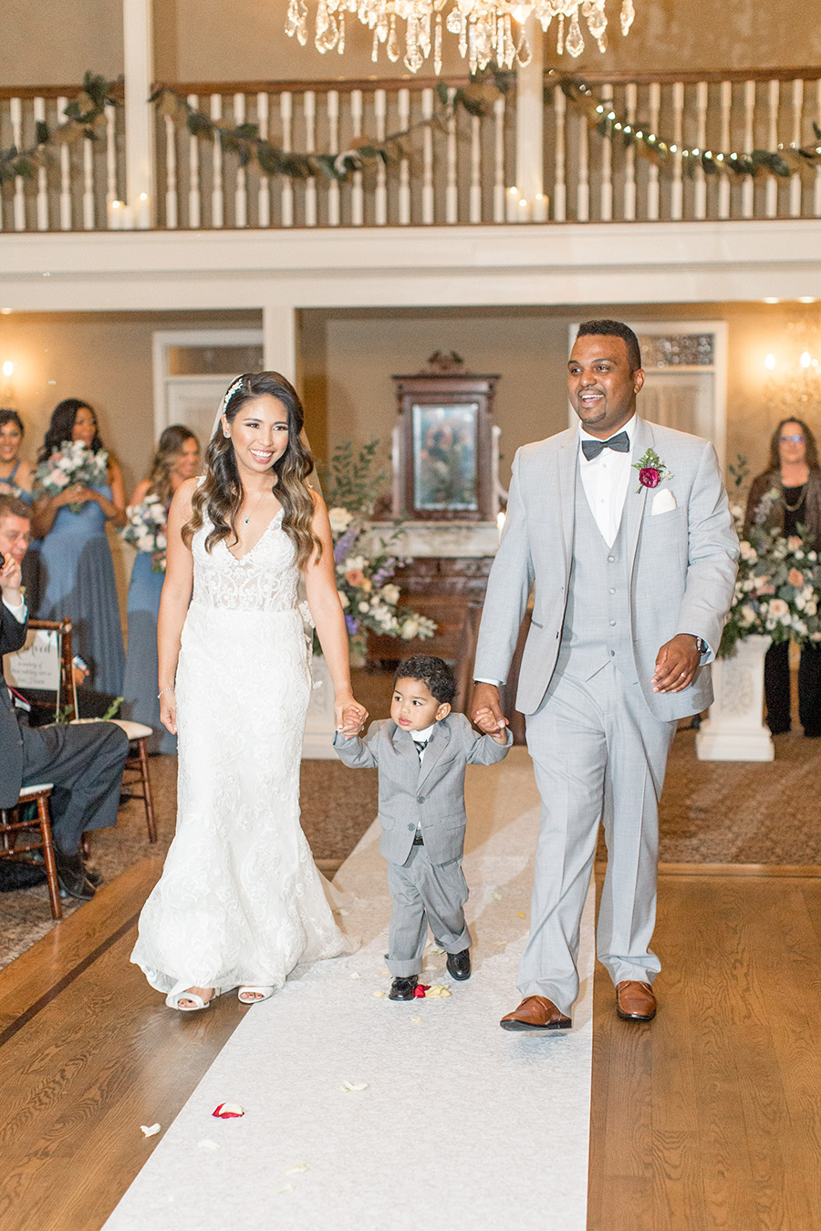 Bride and groom walking down the aisle with their son