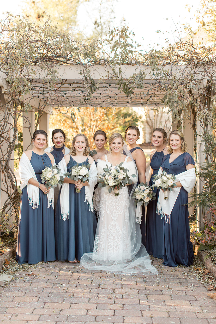 Bride and her bridesmaids in long winter blue dresses and shawls