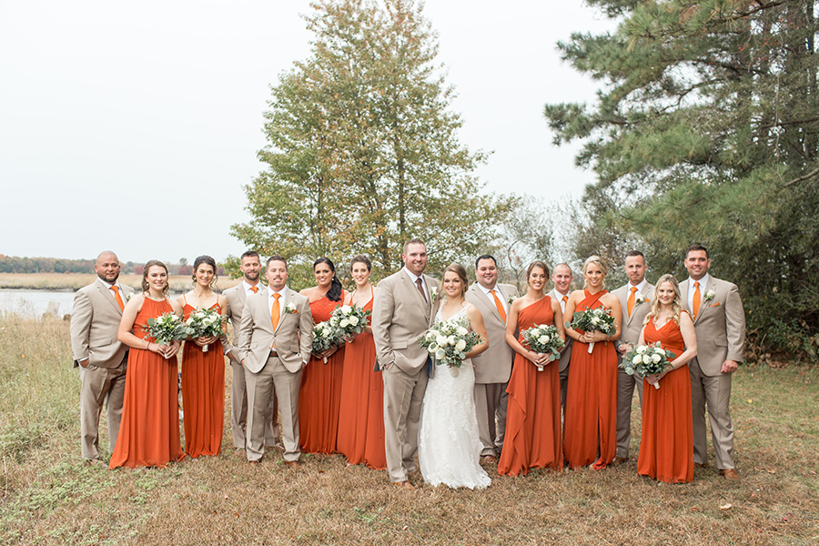 Wedding party in burnt orange dresses and tan suits at Eagle Manor
