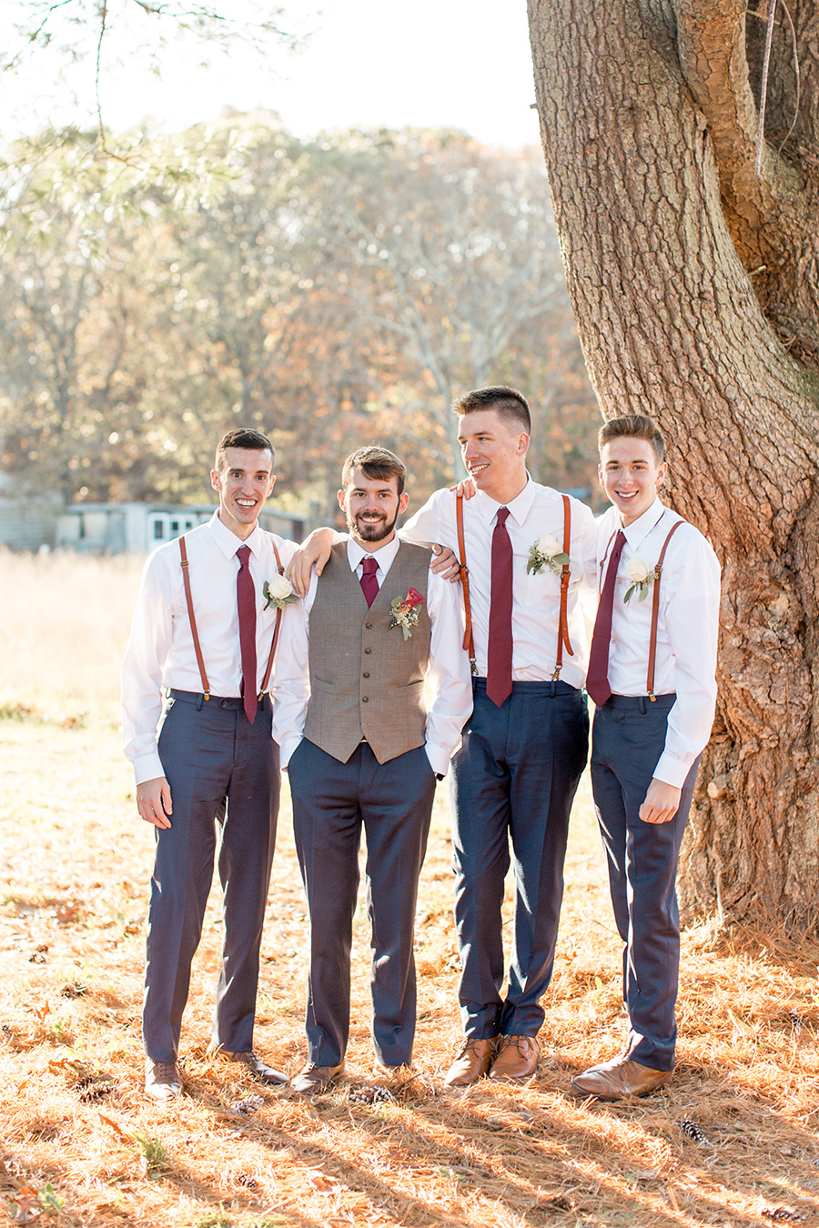 groom with his groomsmen in suspenders and navy pants