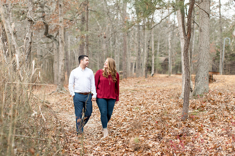 engaged couple walking in the woods at parvin state park