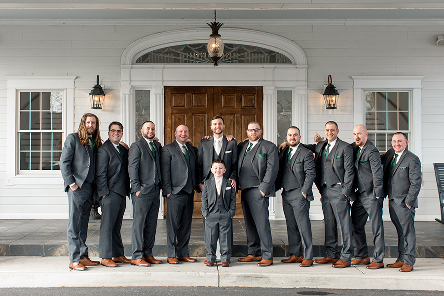 groomsmen with dark gray suits and emerald green accents