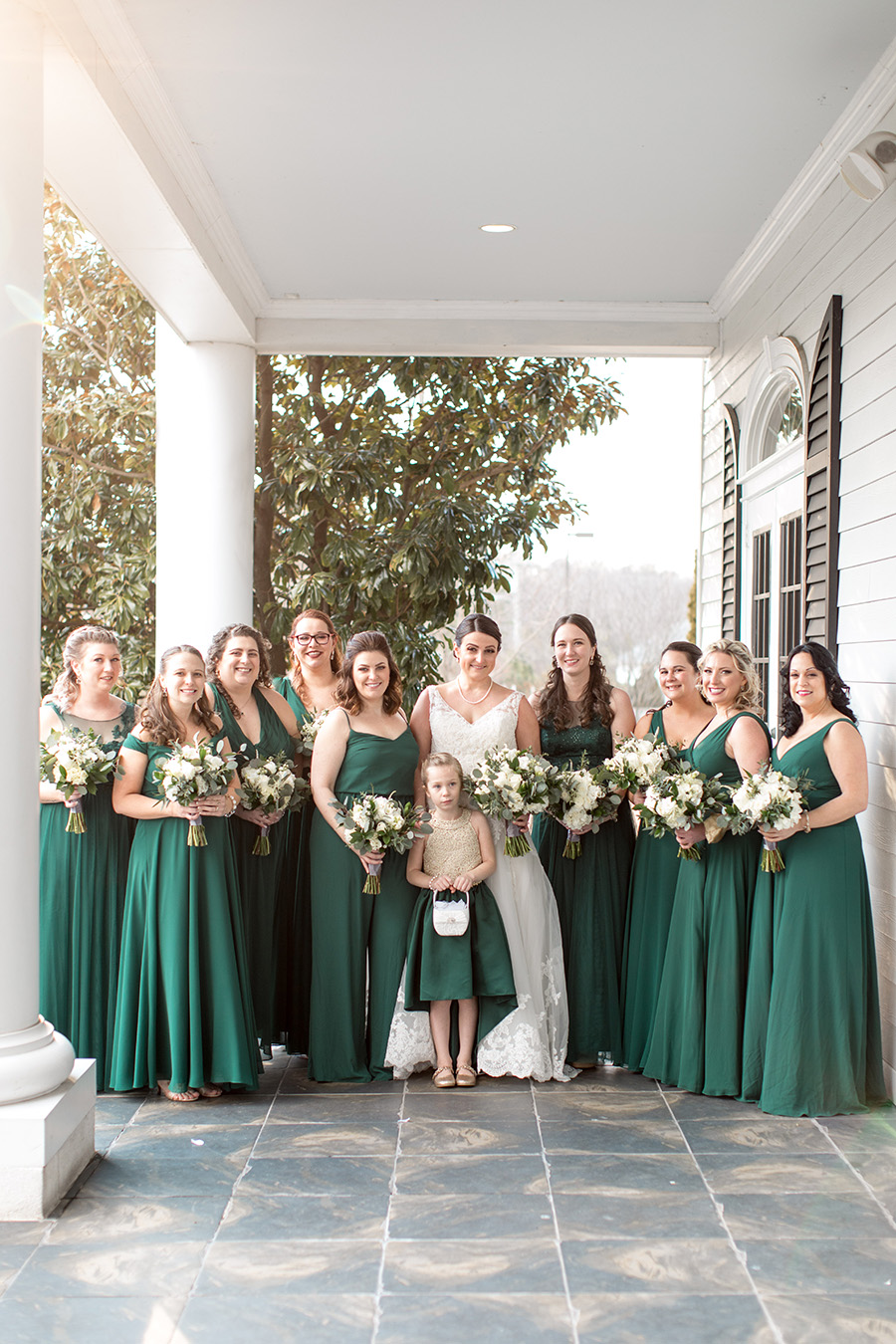 bride and her bridesmaids in emerald green full length gowns with white bouquets