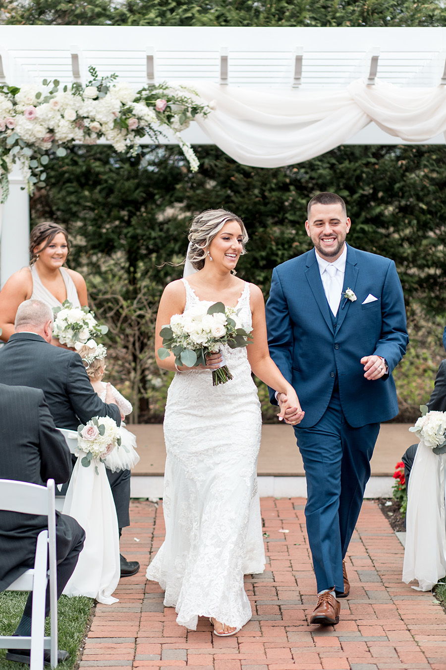 bride and groom walk down the aisle together at their outdoor ceremony at the Bradford Estate