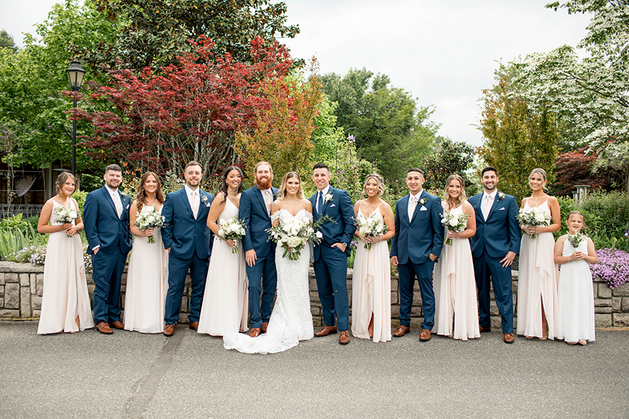 the bridal party color palette was navy blue and blush with the bridesmaids carrying cream and white bouquets