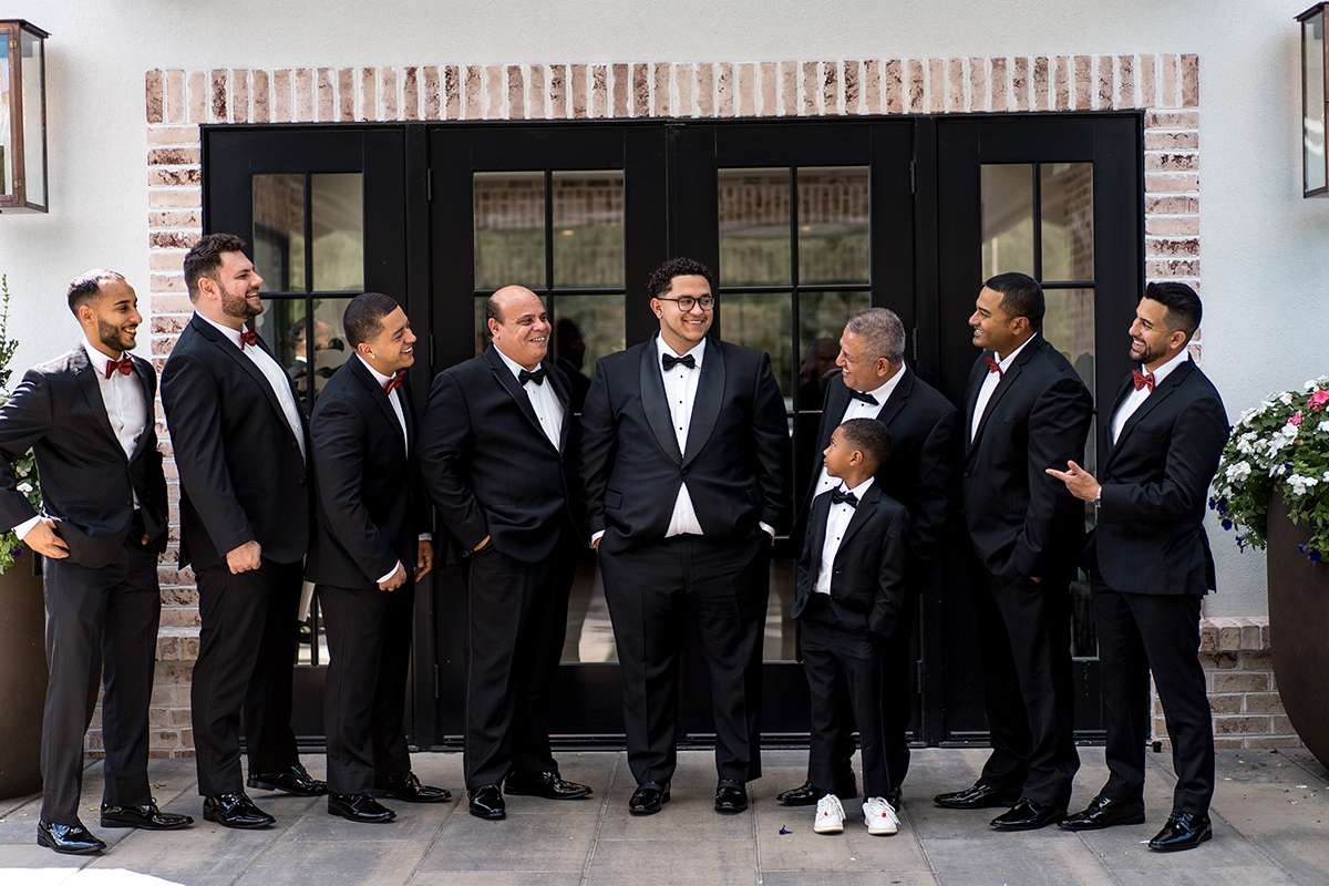 groomsmen in black tuxes and red bow ties