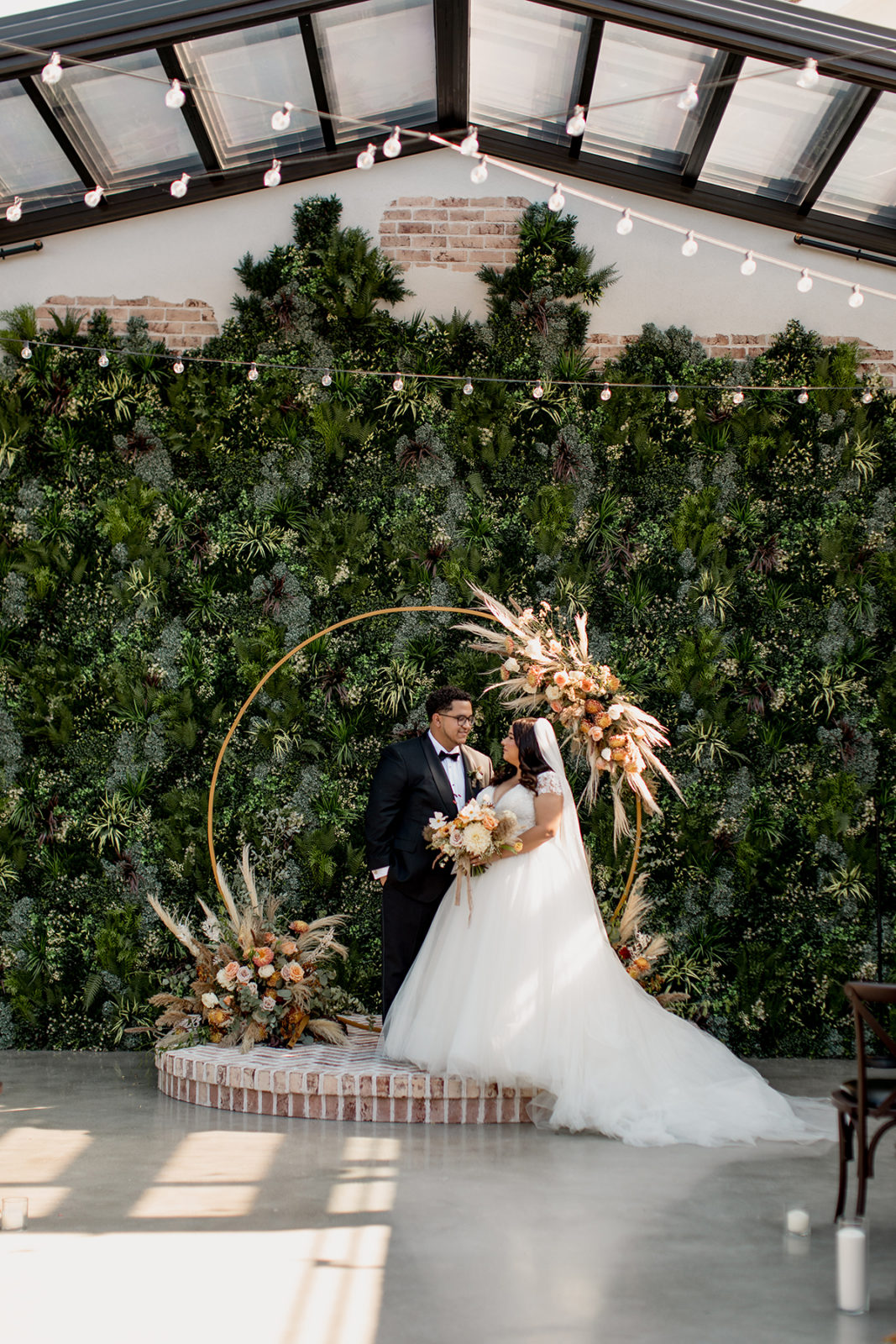 gold circle wedding ceremony arch with a greenery backdrop