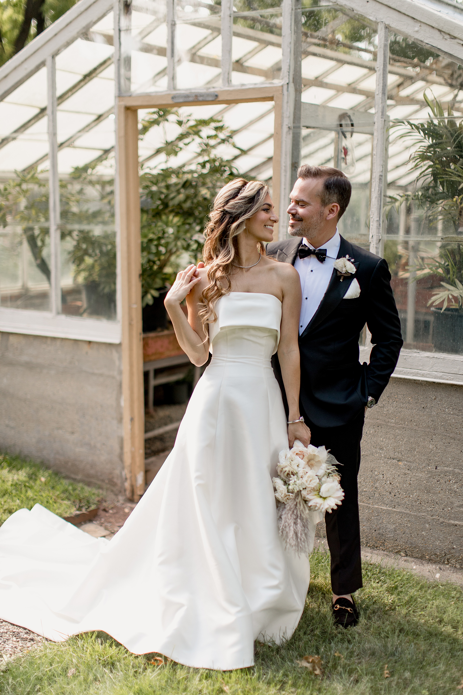bride and groom in front of the greenhouse